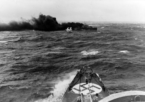 A shell from the Hipper narrowlky misses HMS Glowworm as she crosses the German cruiser's bow