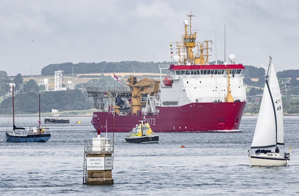 HMS Protector makes her way past yachts and a police launch
