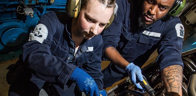 Two engineers fixing equipment on a ship