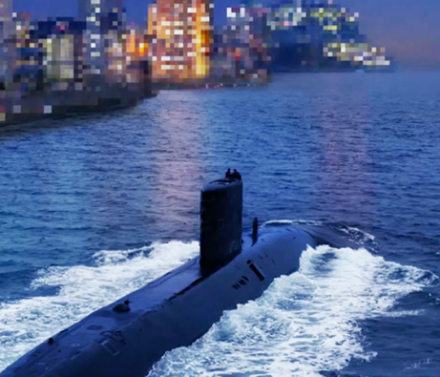 Submarine sailing through the sea by a city at night