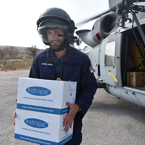 Navy personnel carrying aid packages