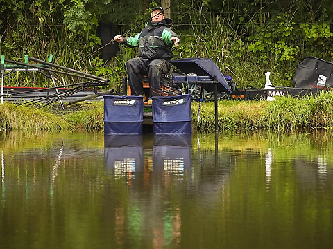 angler on bank surrounded by equipment