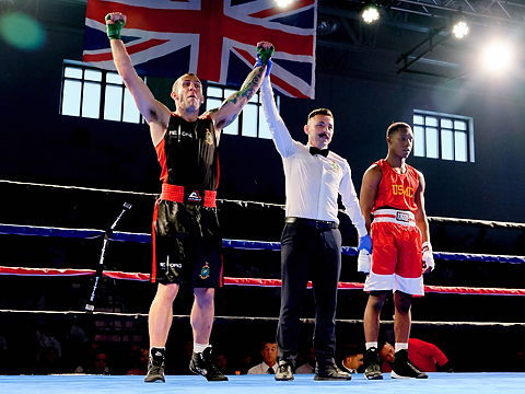 Victorious male RNRM boxer with Union Flag in background