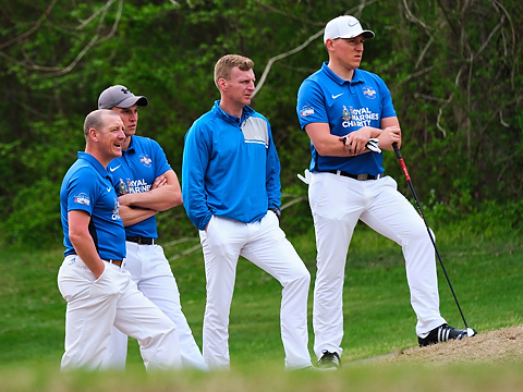 royal marines golfers looking on at play, with play not in shot