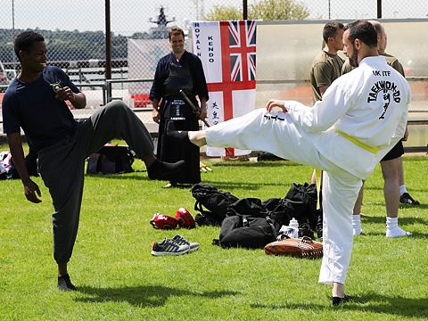 two taekwondo fighters testing each other out with leg reps in outdoor training arena