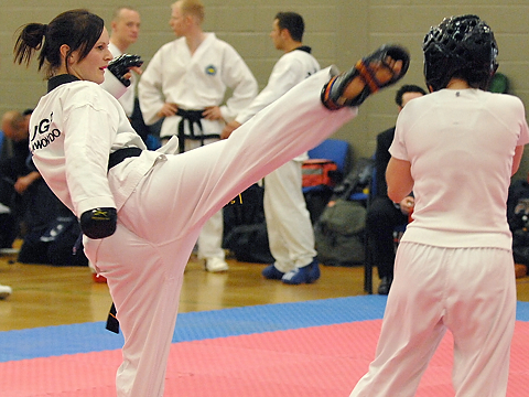 fighter challenges with taekwondo kick directed to opponents head