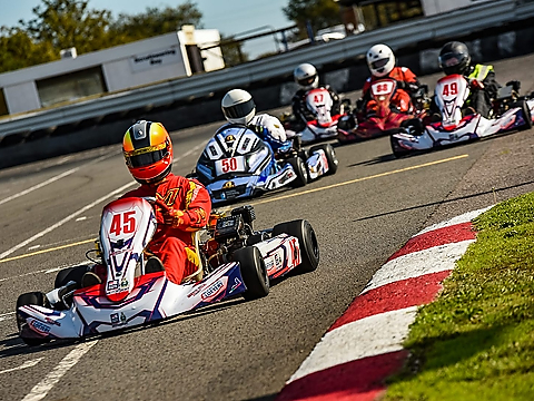 karting racers vying for position  on sunlit straight
