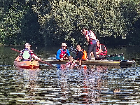 group of canoeists gathered around jetty in lake