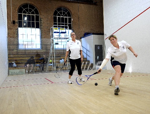 squash player returning back hand against wall