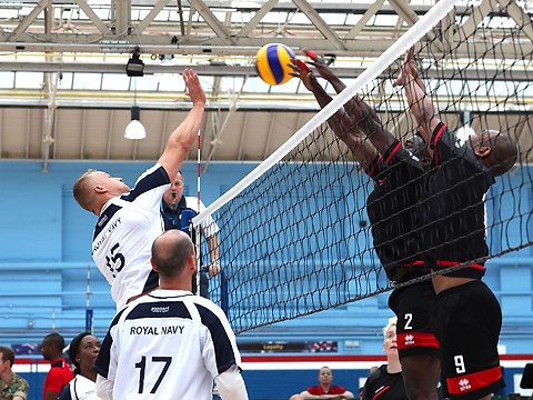 royal navy team in white competing at net with opponents dressed in black