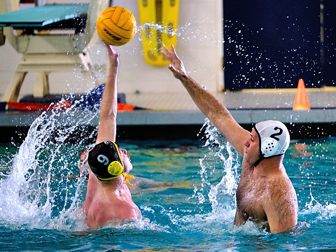 water polo players compete for ball in air