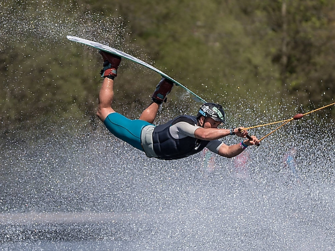 wakeboarder flying through the air with spray all around