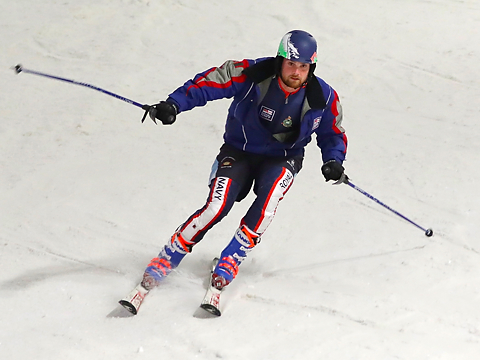 royal navy skier in blue on slopes, downhill, with sticks open