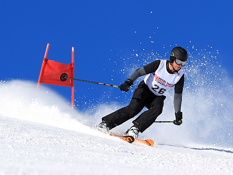 downhill skier on slopes with blue sky