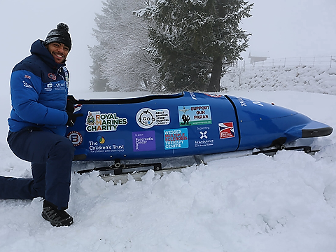RNWSA Bobsleigh Taylor Lawrence with bob in snow setting with snow-covered pine in background