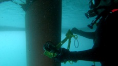 xdg diver in scuba gear monitoring underwater structure