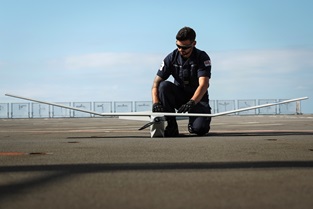 AB Tom Halton prepares a Puma drone for a sortie from HMS Albion