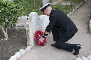 Commander Nick Baker places a wreath on the grave of a sailor killed at Trafalgar