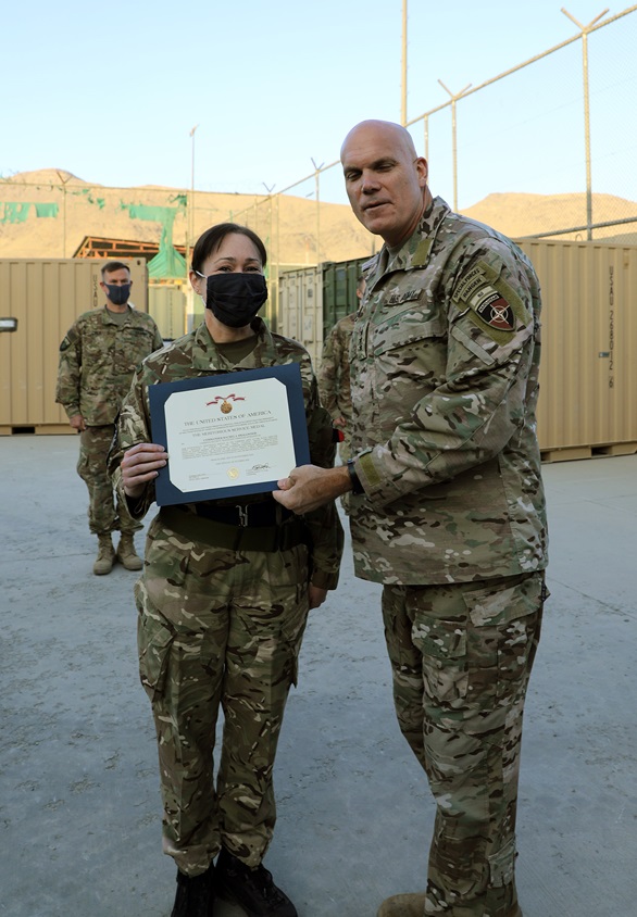Lieutenant General John Deedrick presents Commander Rachel Smallwood with the Meritorious Service Medal citation