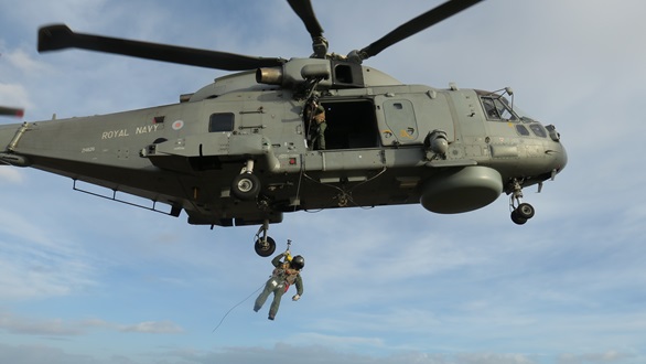 A crew member from 814 NAS is lowered onto the island