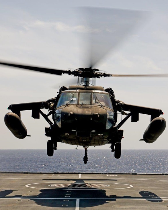 A Black Hawk lifts off from the deck of Wave Knight after refuelling