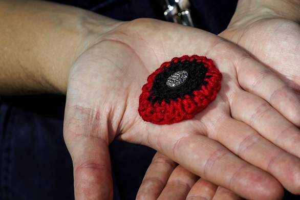 AB Michelle Walters holds one of the poppies she crocheted