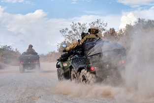 Royal Marines on 6-wheel CanAm vehicles race down a Cypriot track