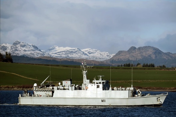 HMS Blyth sails down the Firth of Clyde past snow-capped peaks in the distance