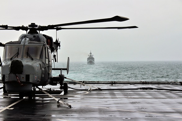 A Wildcat helicopter of 815 Naval Air Squadron lashed down on the deck of destroyer HMS Defender in the Channel, August 14 2019. Following Diamond is Indian guided-missile frigate Tarkash, also taking part in Exercise Konkan.