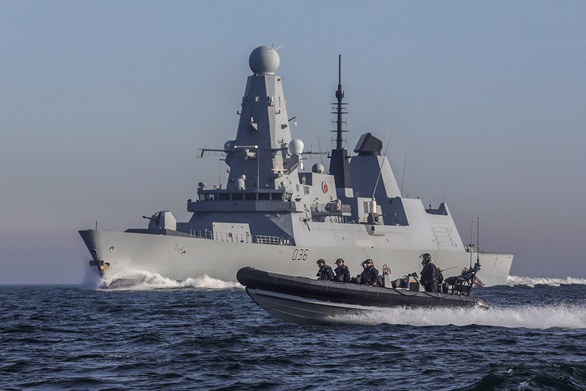 HMS Defender with her sea boat in the foreground