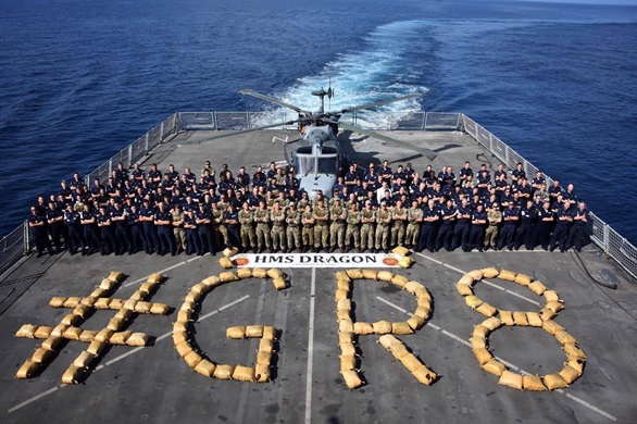 The ship's company with their haul of seized drugs on the flight deck of HMS Dragon