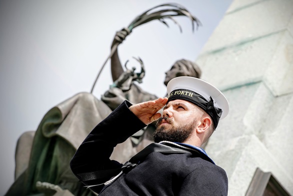 A sailor from HMS Forth salutes beneath the impressive Battle of the Falklands Memorial