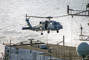 A US Navy Seahawk hovers over HMS Montrose