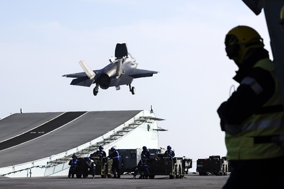 Aircraft Handlers watch as an F-35 takes off from HMS Prince of Wales