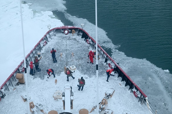 Crew shovel snow off the Polar Star's forecastle