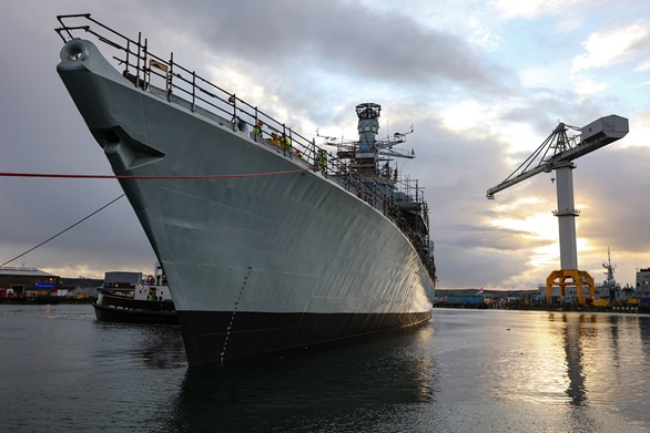 HMS Somerset is manoeuvred by a tug after emerging from the refit shed