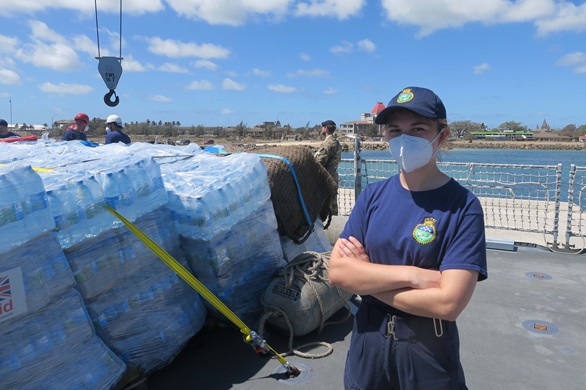 Sub Lt Kate Winter with piles of bottled water awaiting delivery