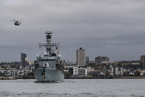 A Merlin flies past HMS Sutherland as the frigate returns to Plymouth from her last day at sea until 2023