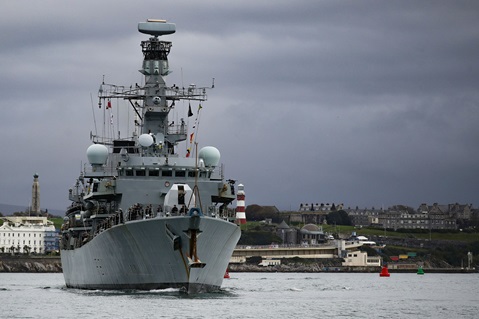 A gunmetal HMS Sutherland on a gunmetal day in Plymouth with the Hoe in the background
