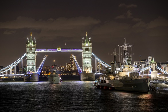 HMS Tyne sailing under the iconic Tower Bridge in London to moor alongside the equally iconic WWII Cruiser HMS Belfast.