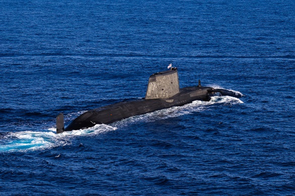 A rare appearance on the surface for an Astute-class submarine accompanying the Carrier Strike Group