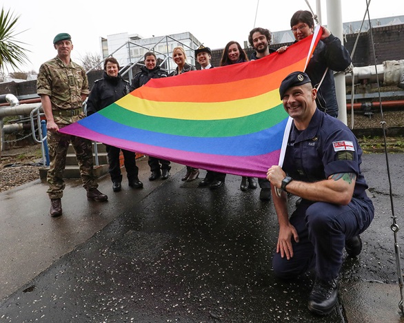 Rainbow flag with serving members of Royal Navy and Royal Marines personnel at HM Naval Base Clyde