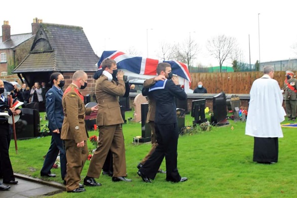Military pallbearers carry the coffin of the reinterred veterans