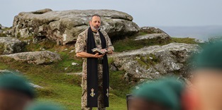 Chaplain conducting a service in a field
